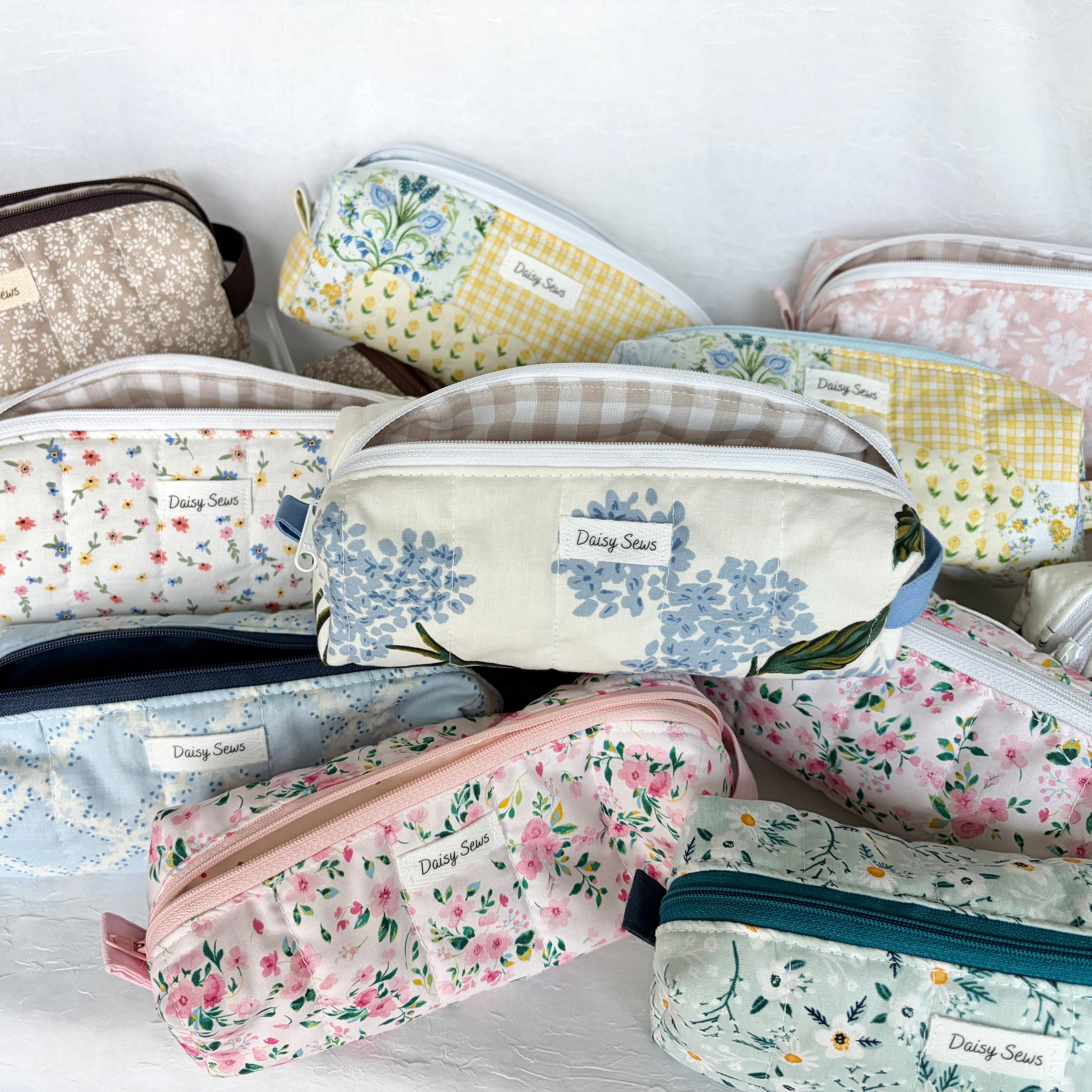 Pile of bright floral pencil bags with zippers open showing peaks at their interiors