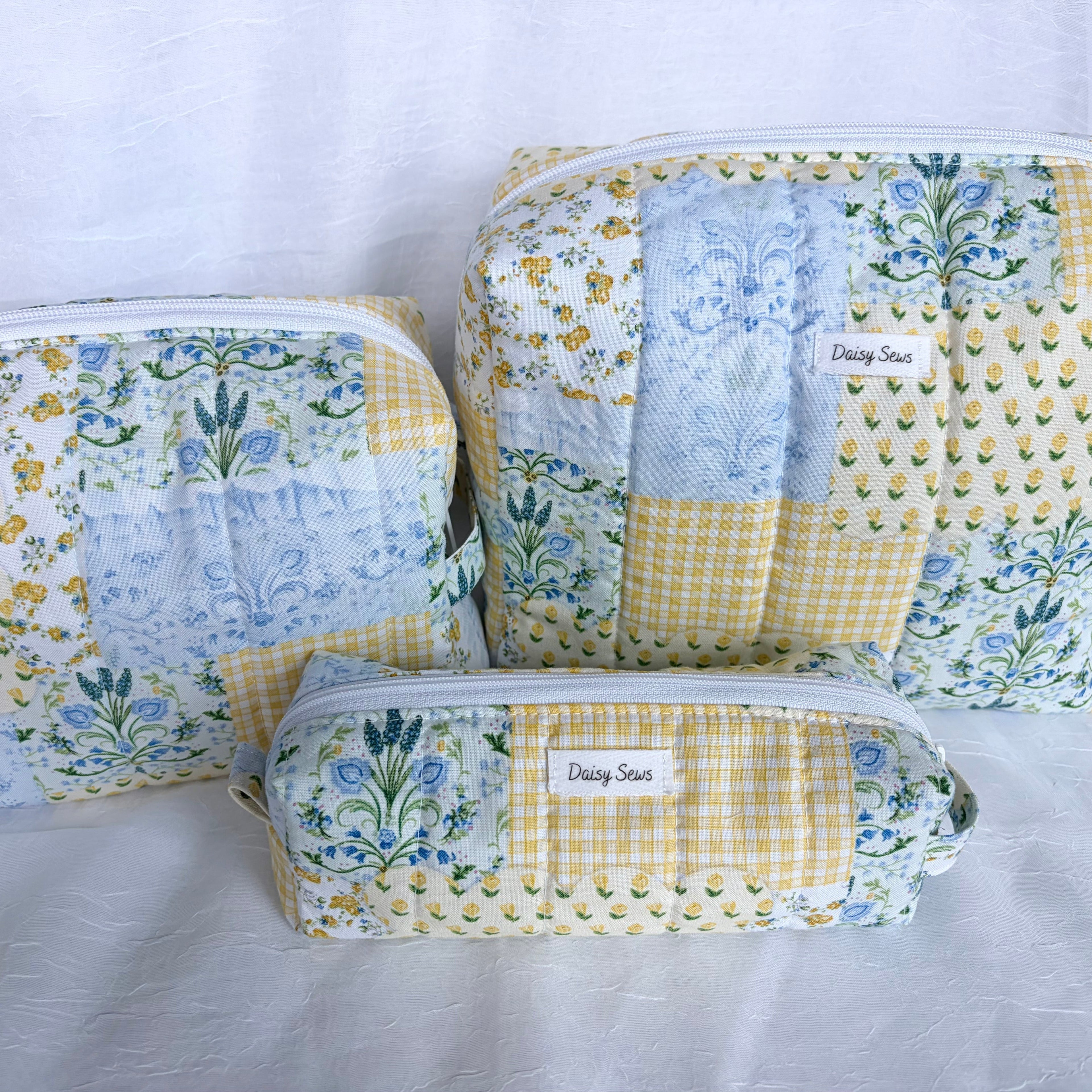 matching set of pencil toiletry and large toiletry bags in blue and yellow floral patchwork