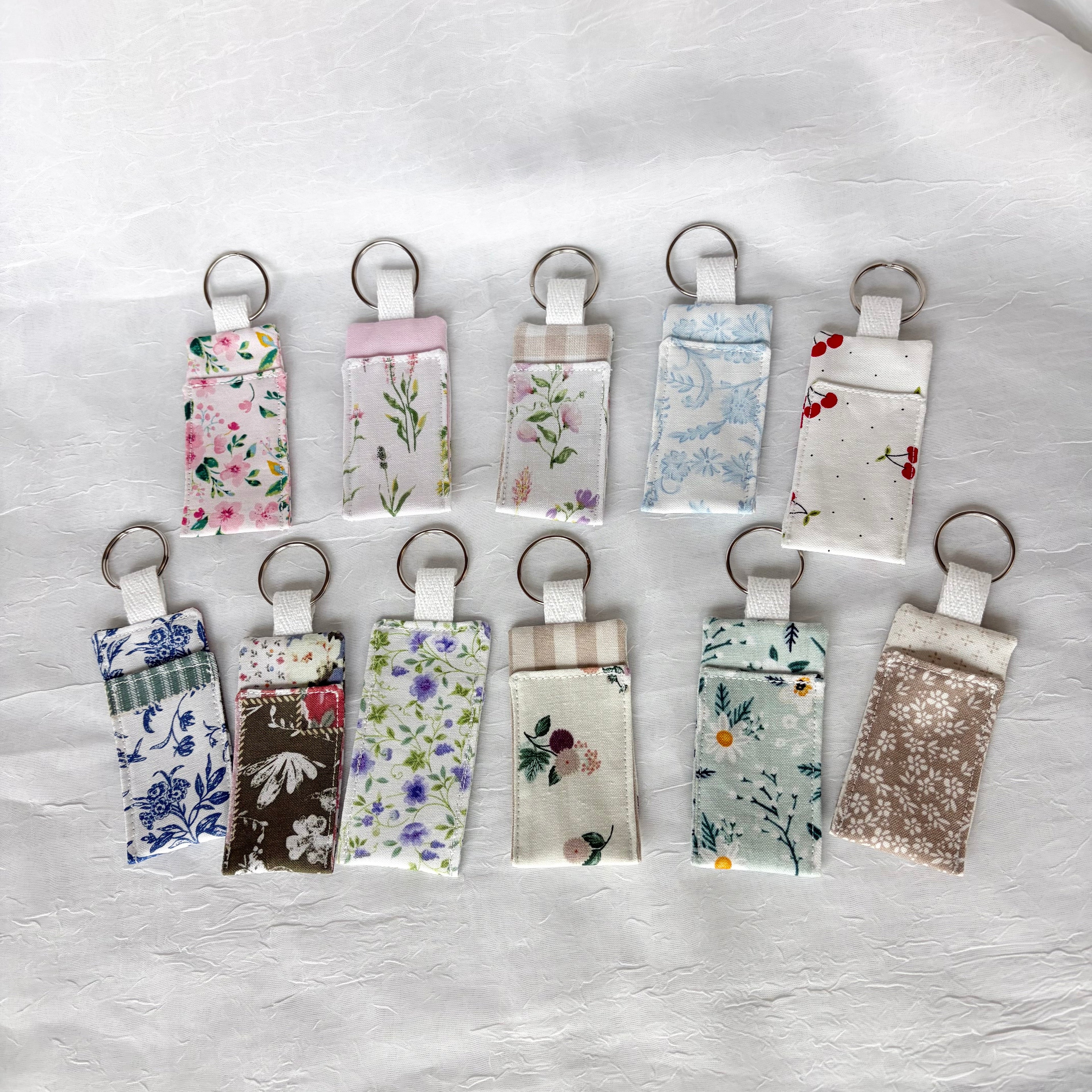 two rows of chapstick holders in bright and muted florals on white background