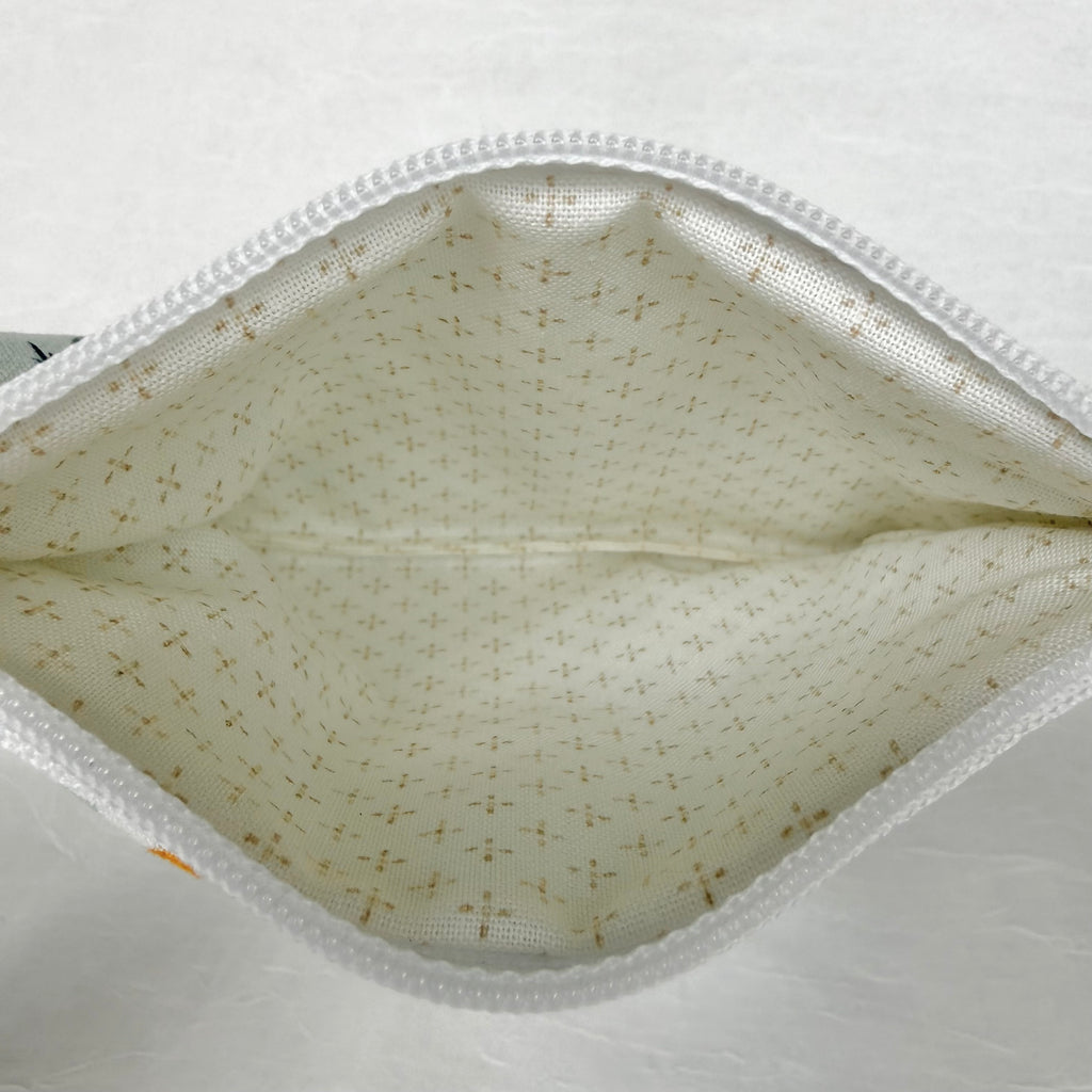 Cream with brown dots in cross pattern interior with white zipper at top opening on white background