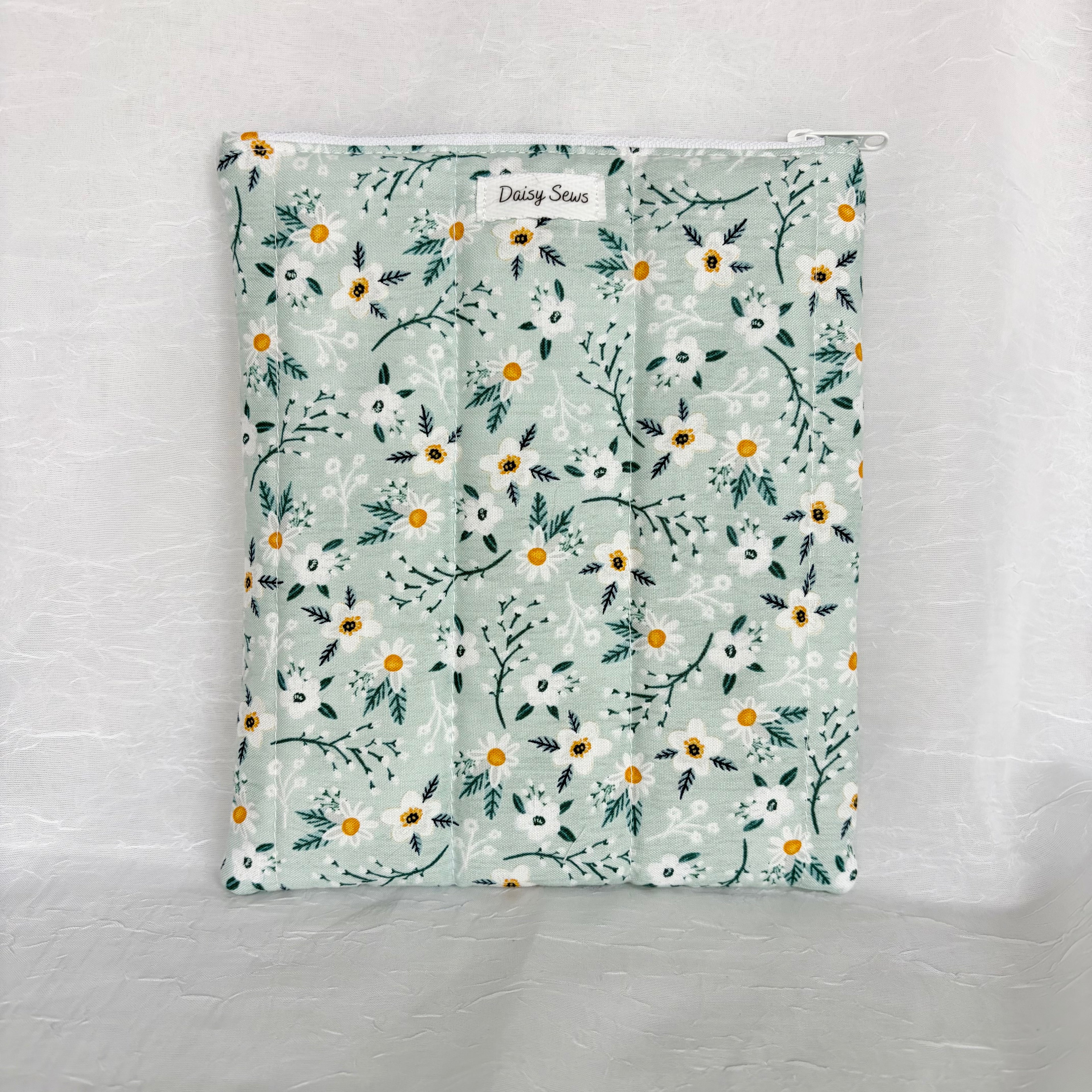 blue with white flowers and teal leaf design plush, flat pouch with white zipper on white background