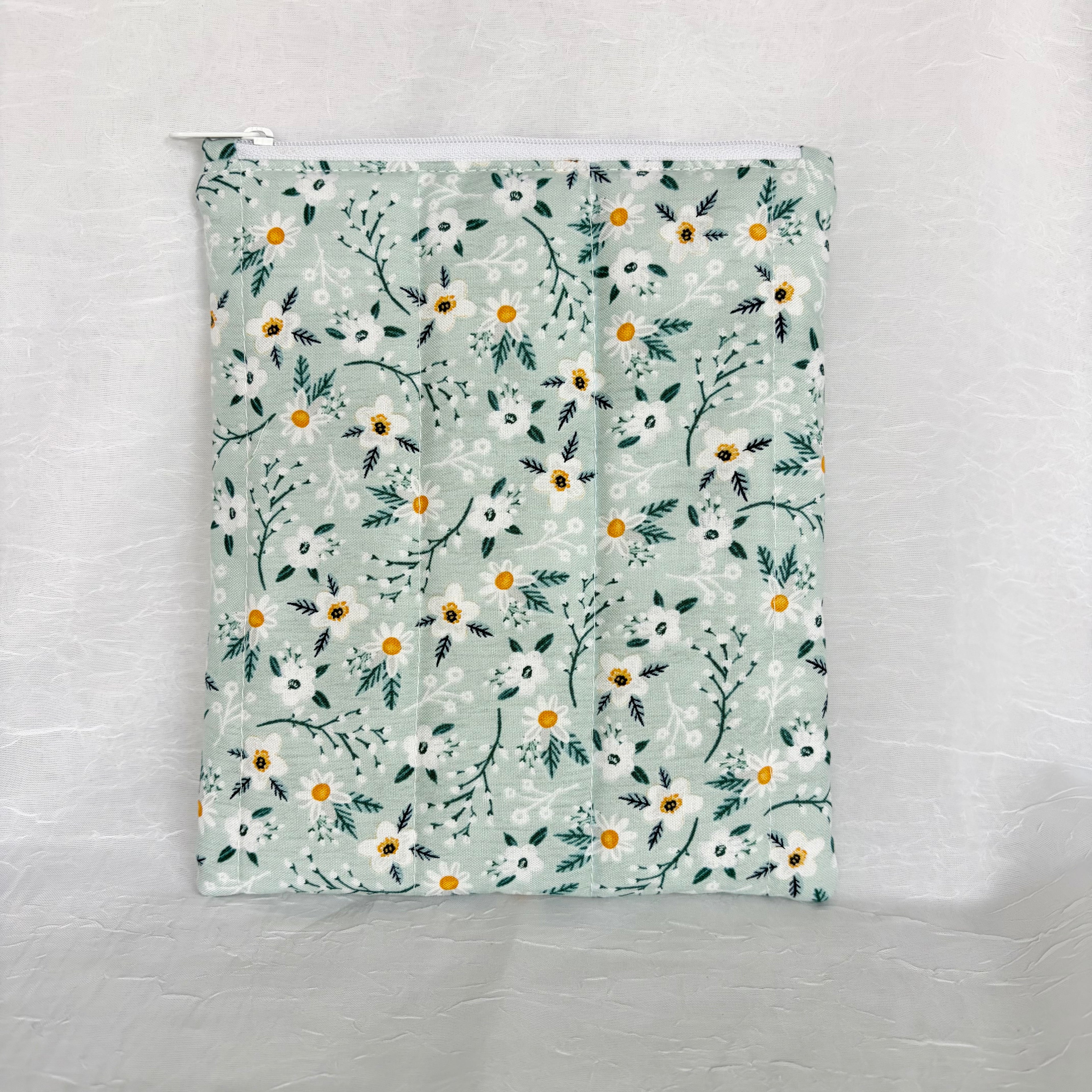 back blue with white flowers and teal leaf design plush, flat pouch with white zipper on white background