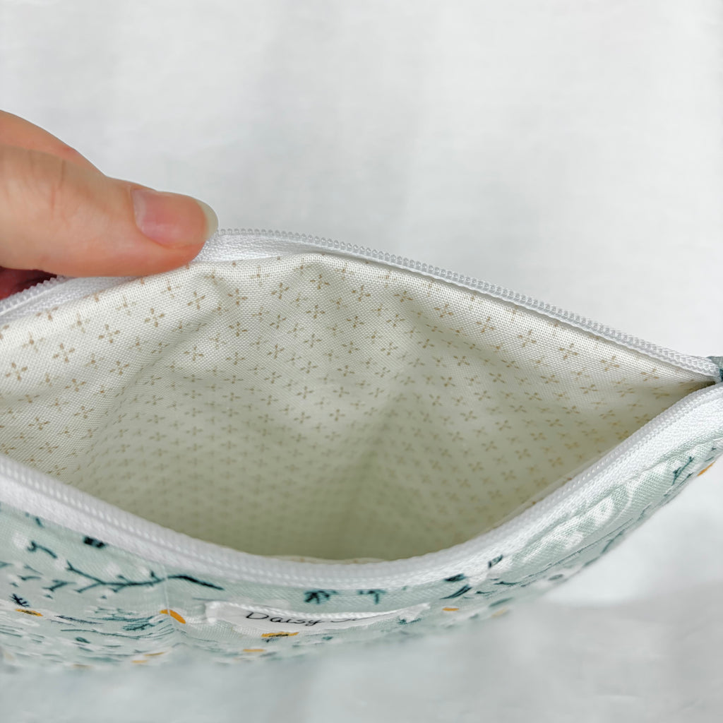 cream with brown dots in cross patterned interior with white zipper at top opening on white background