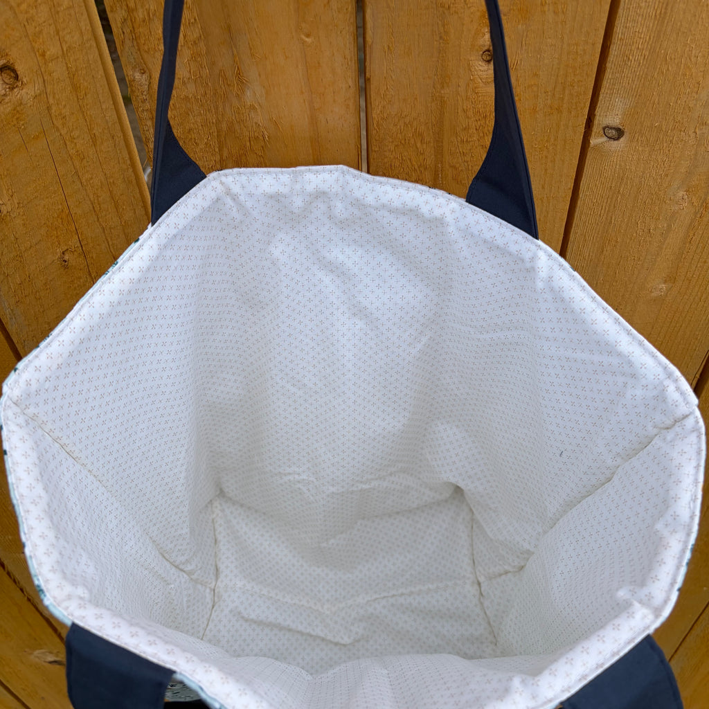 cream liner with small brown dots, navy handles on a wooden background