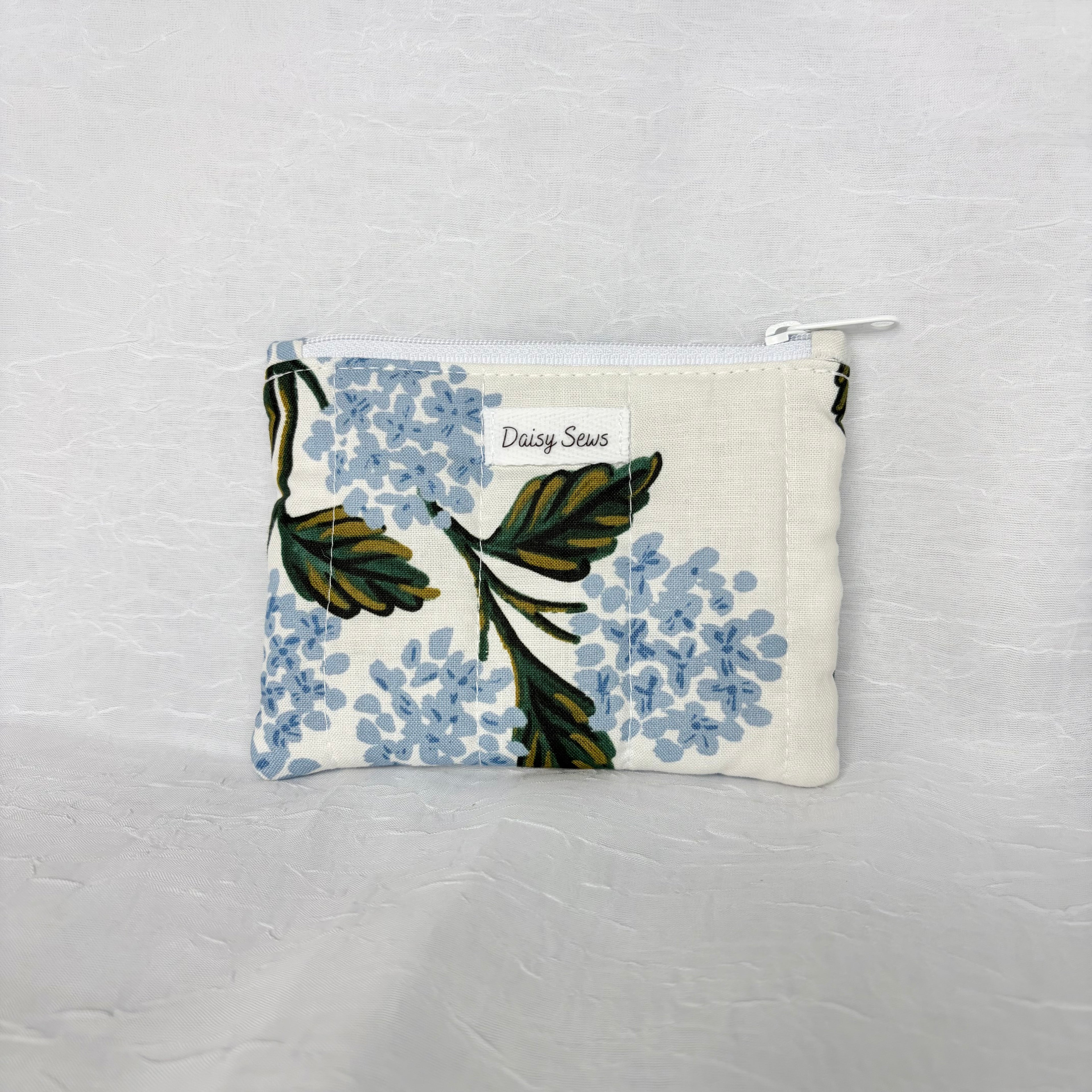 Blue Hydrangea with green leaf patterned Pouch with white zipper on white background