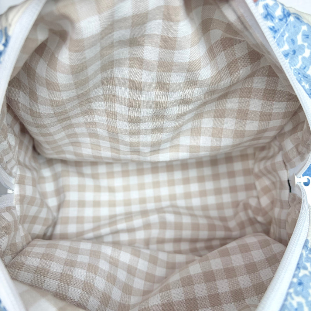close up of beige gingham liner and white zipper at top opening