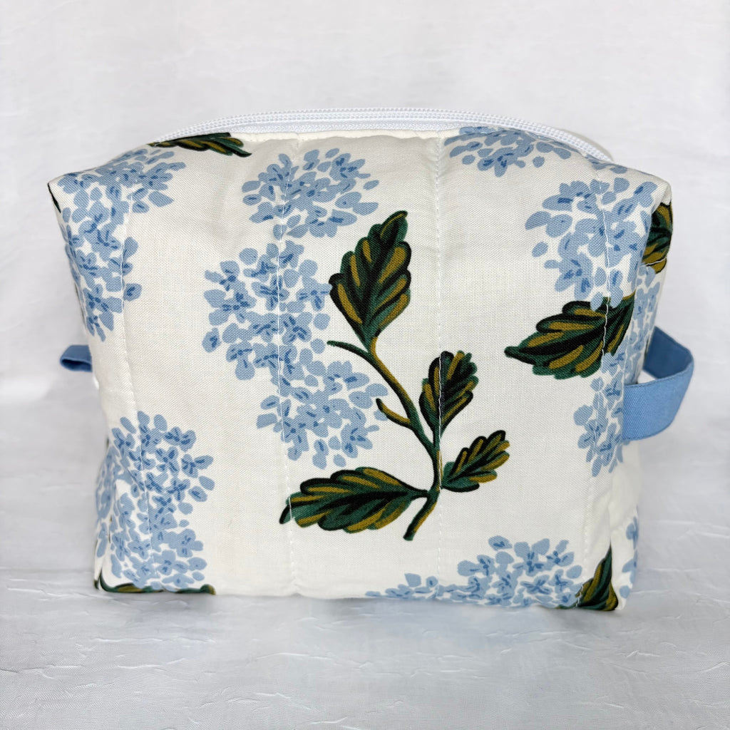 Back view of large Blue Hydrangeas with green leaf designed boxy bag with blue accents on white background