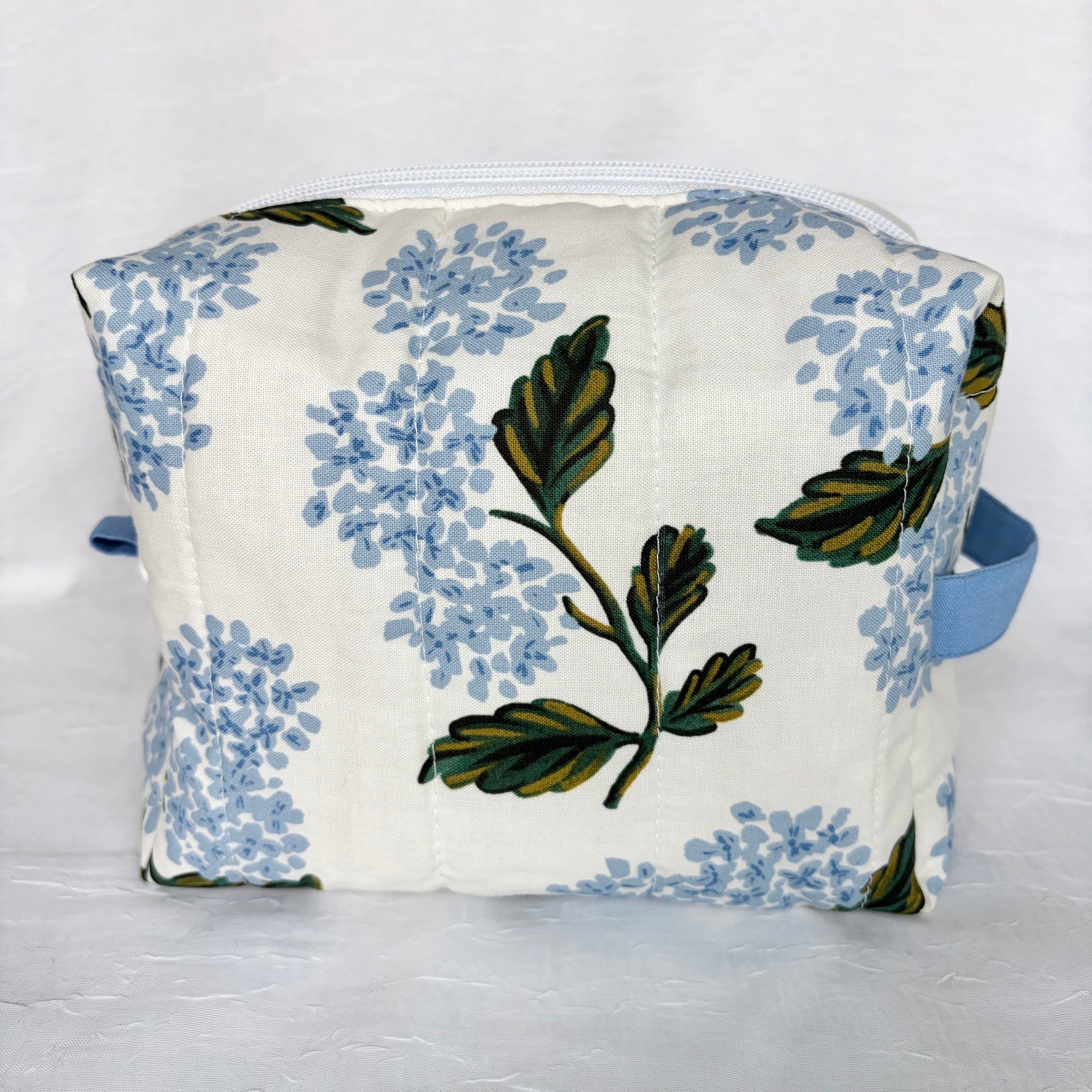 Back view of large Blue Hydrangeas with green leaf designed boxy bag with blue accents on white background