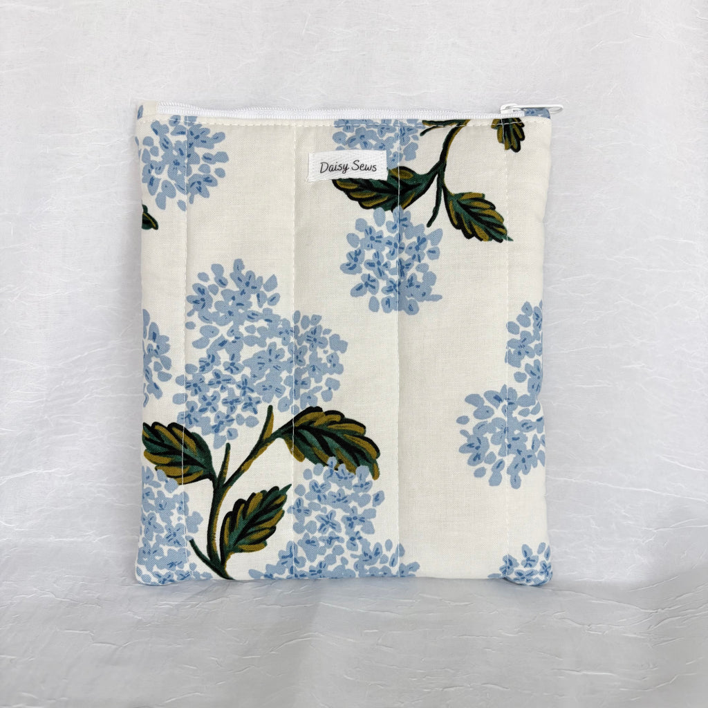 Large Blue Hydrangea and green leave design on white fabric plush, flat pouch on white background