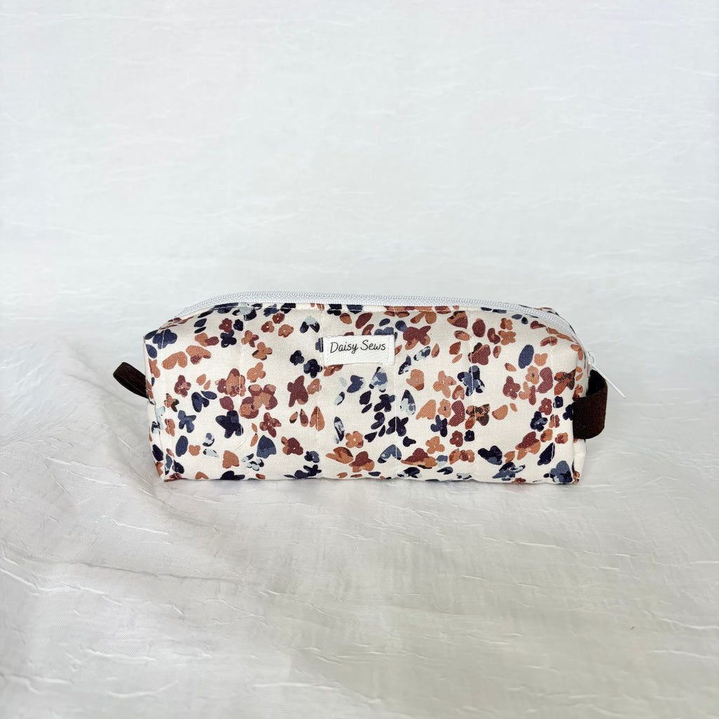 blue and mauve speckled white short and long bag on a white background with brown handle and tab and white label