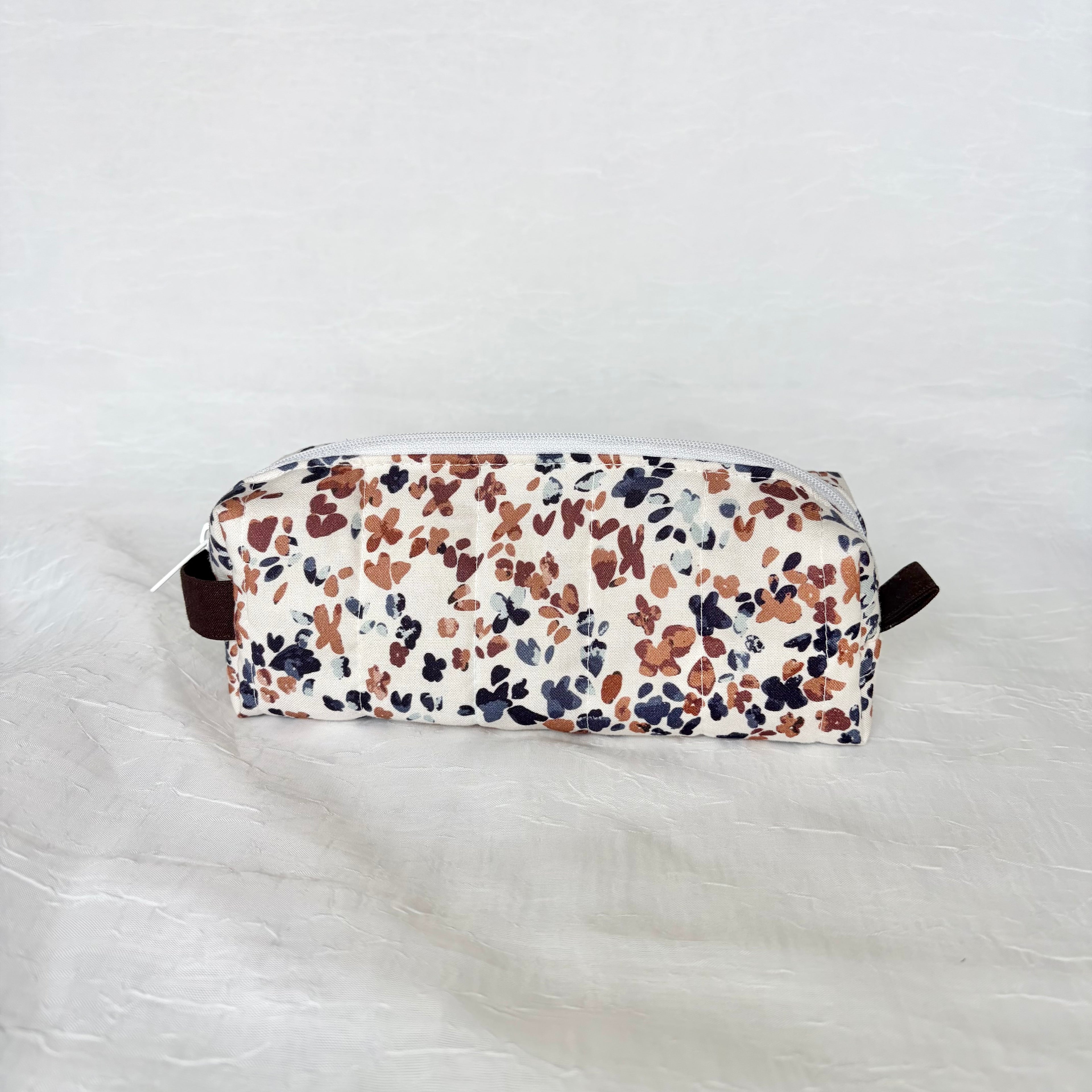 back view of a blue and mauve speckled white short and long bag on a white background with dark brown tab and handle