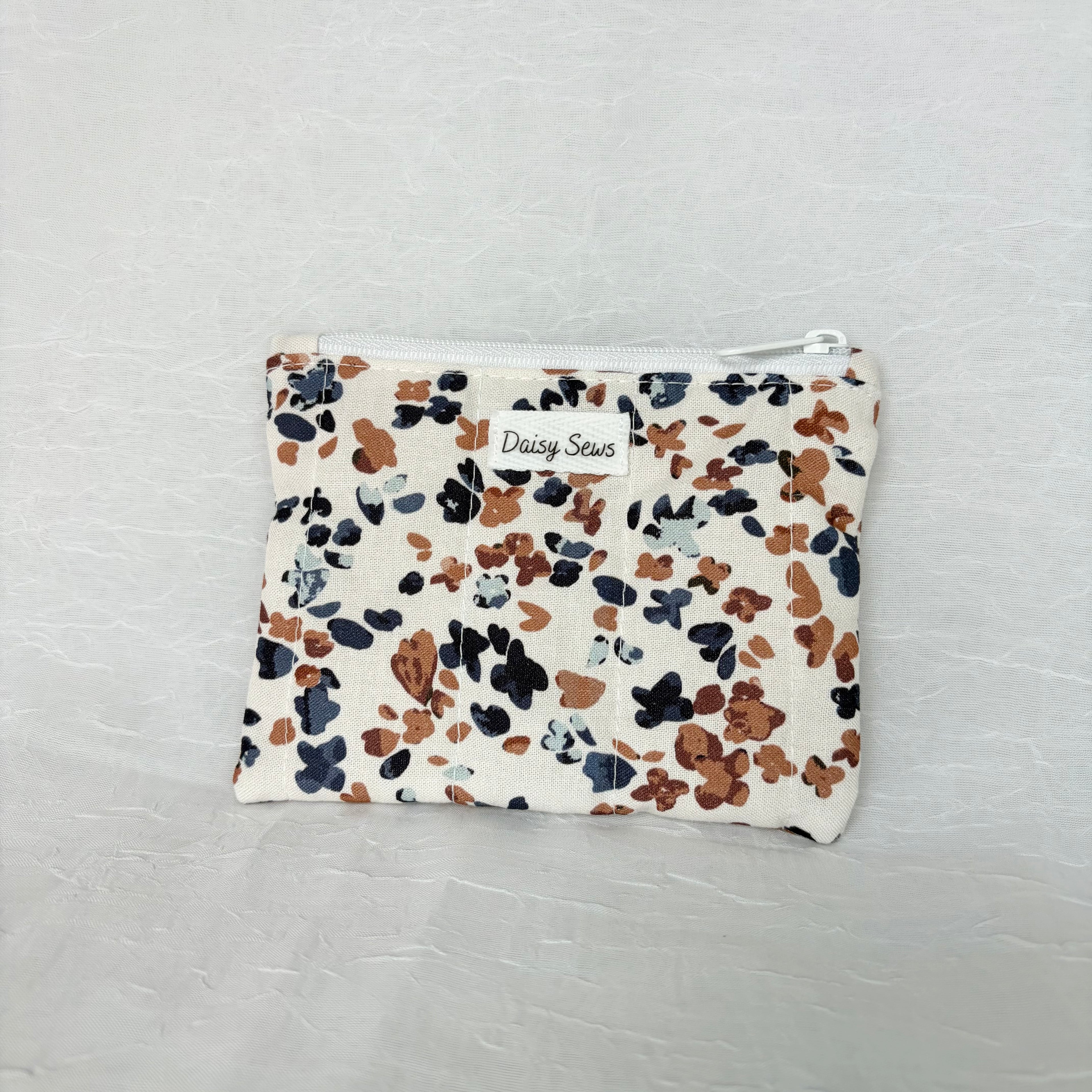 Blue and Mauve speckled pouch with white zipper on white background