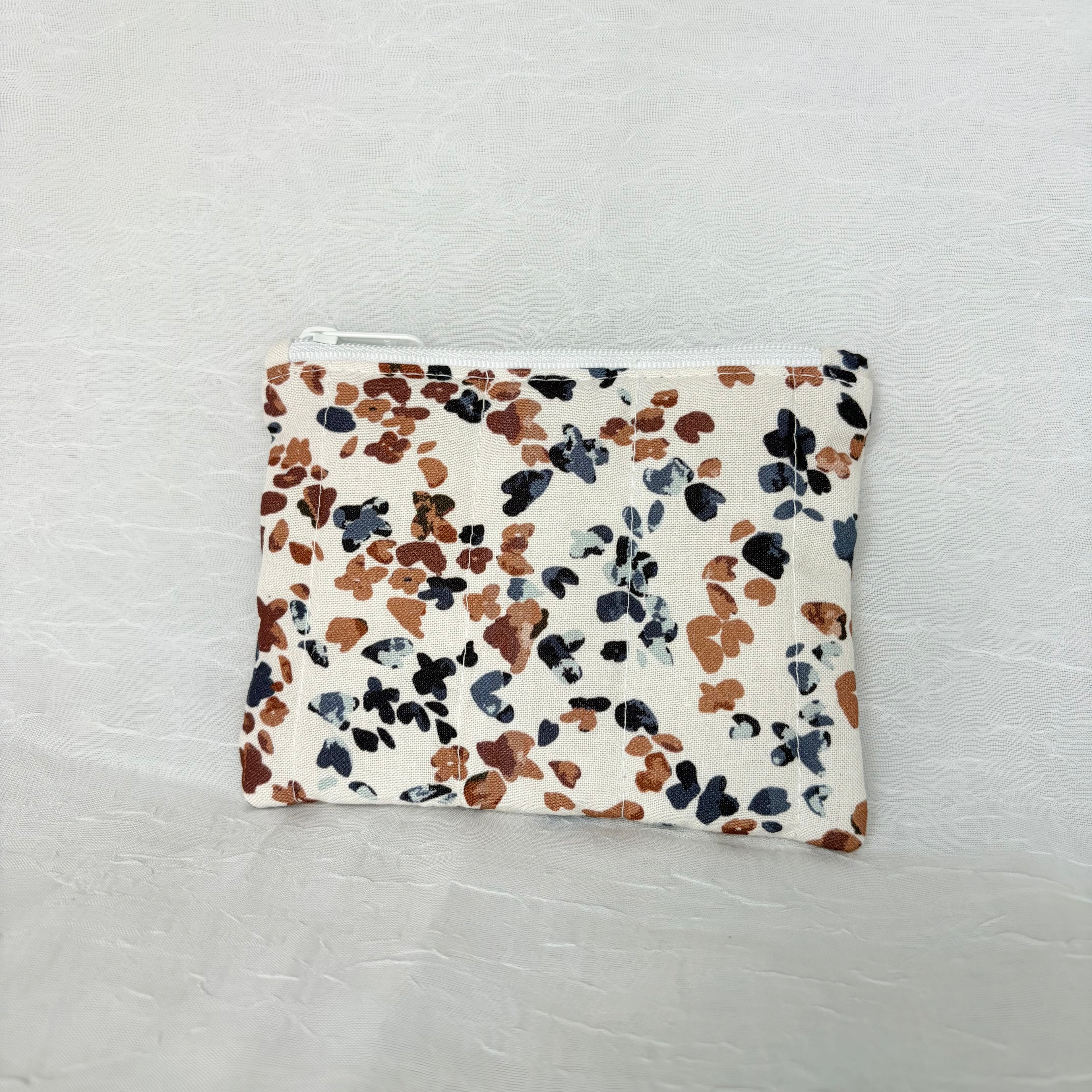 back side of Blue and Mauve speckled pouch with white zipper on white background