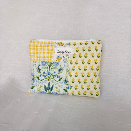 Blue and Yellow floral Patchwork small Pouch with white zipper and white centered label on white background
