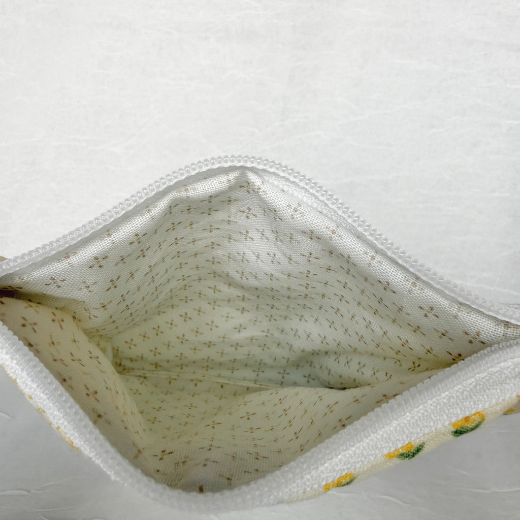 Cream with brown dots in cross pattern interior with whit zipper at top opening on white background