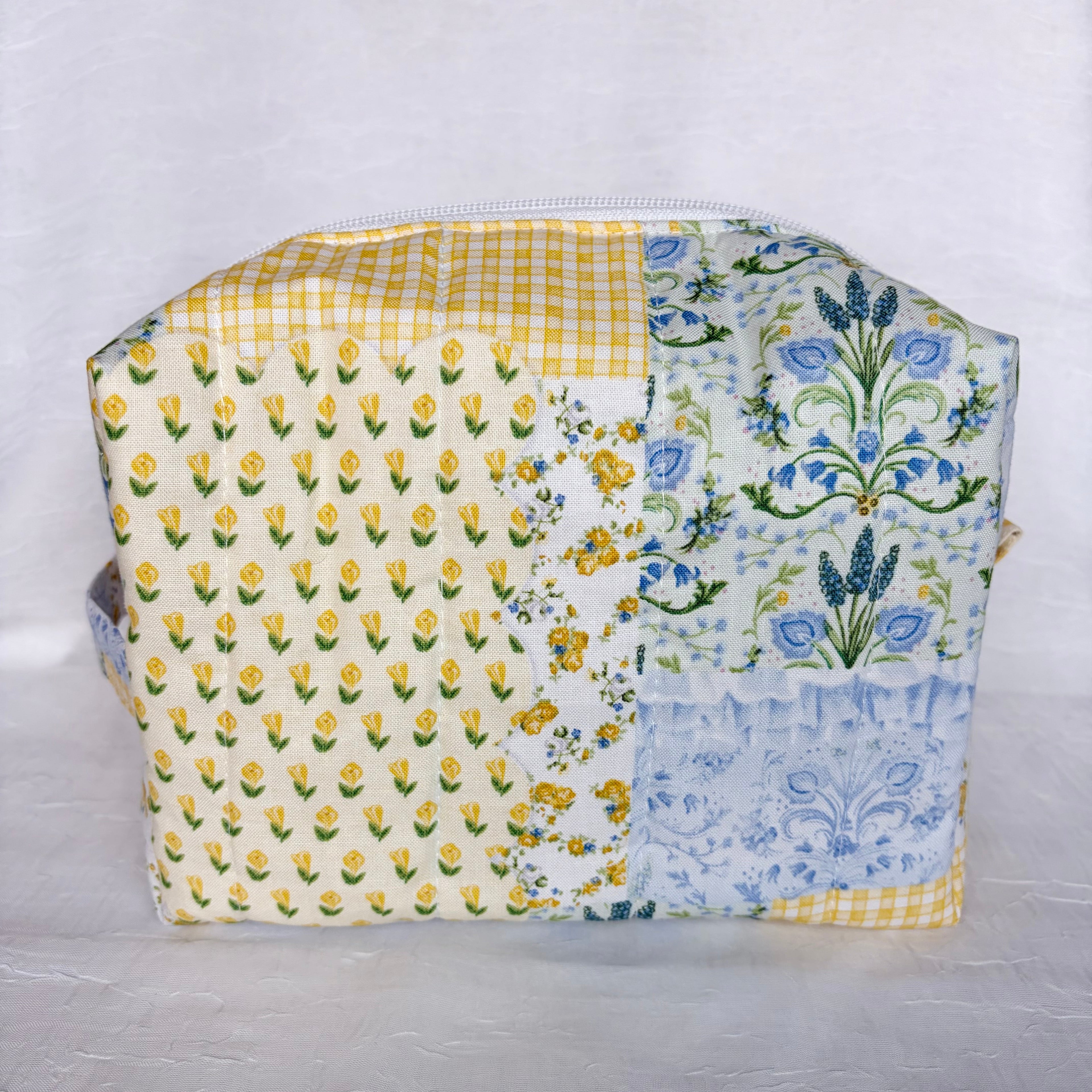 Back View of Blue and Yellow floral Patchwork boxy bag with white zipper against white background
