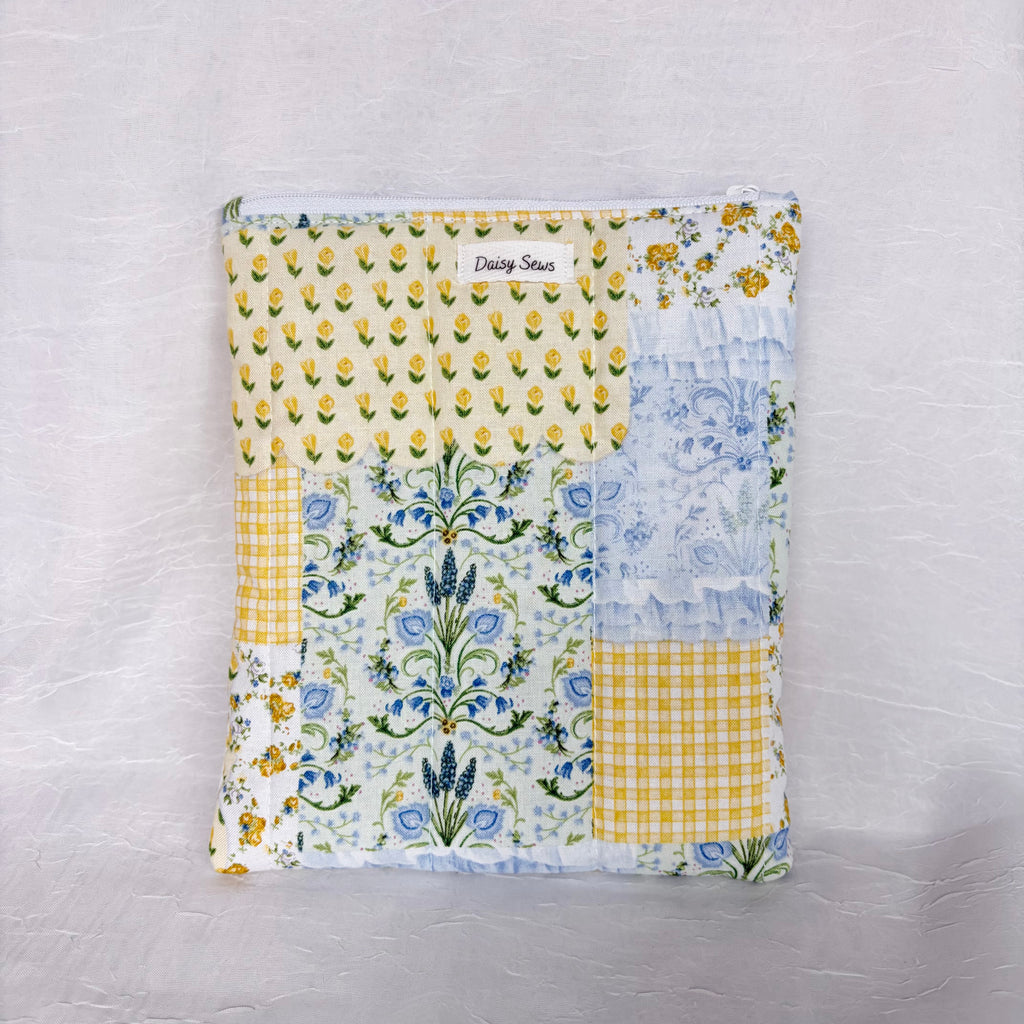 Blue and Yellow floral Patchwork fabric, plush, flat pouch with white zipper on white background