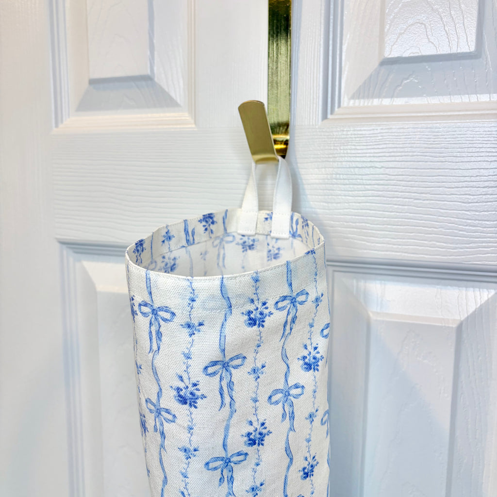 close up of white loop hanging on gold hook against white door