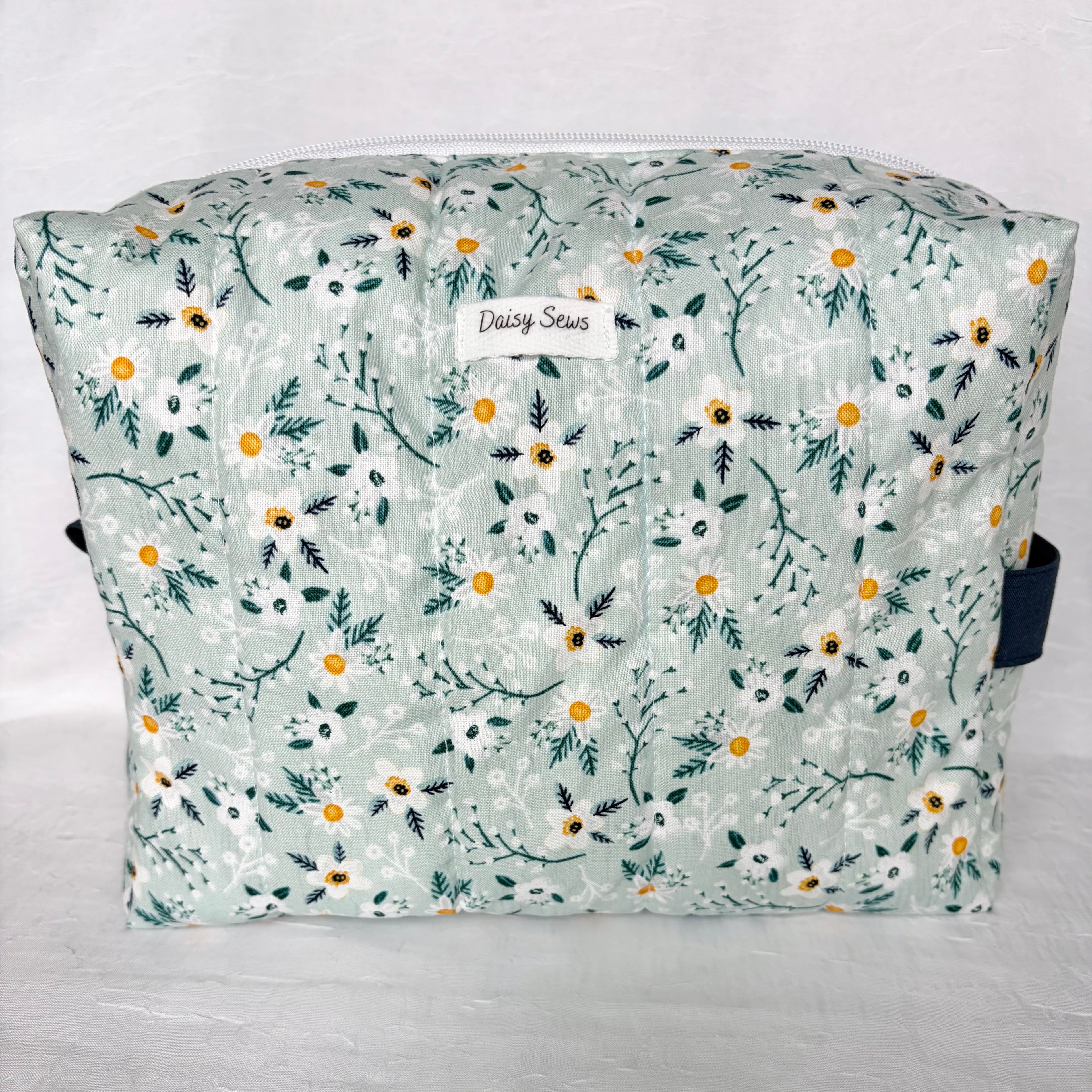  blue with white flowers and teal leaf patterned boxy bag with white zipper and label on white background