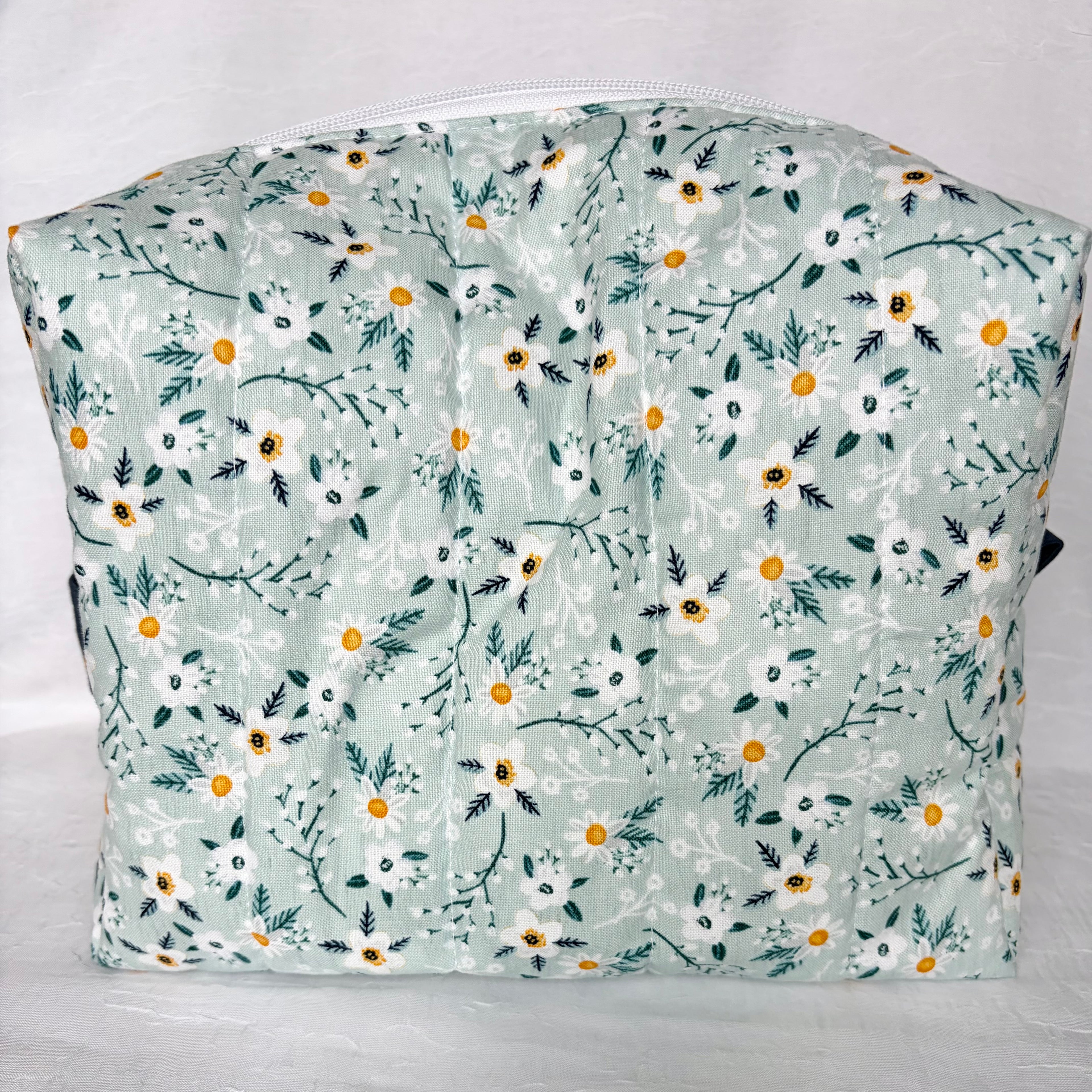 back view of blue with white flowers and teal leaf patterned boxy bag on white background