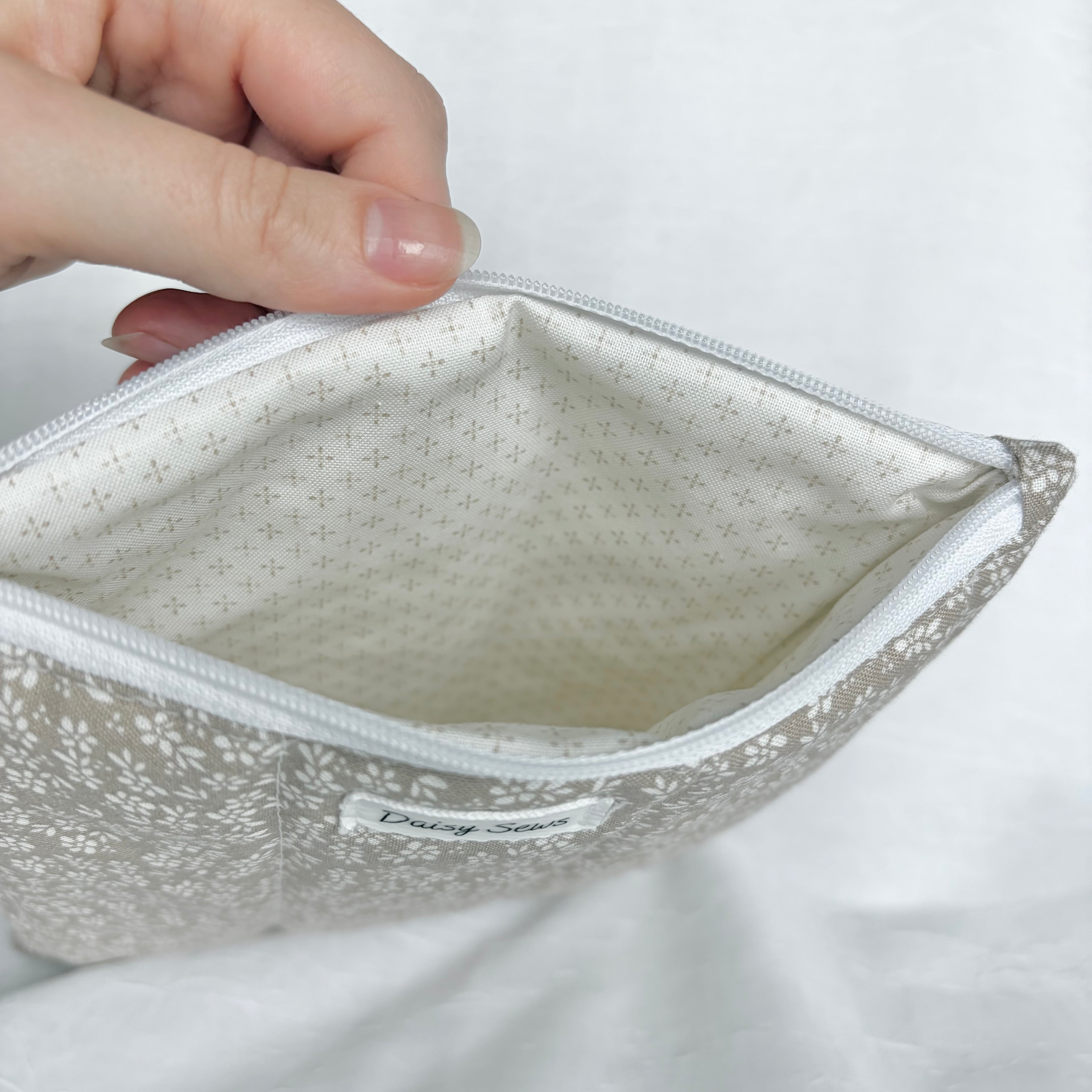 cream with brown dots in cross pattern interior with white zipper at top opening