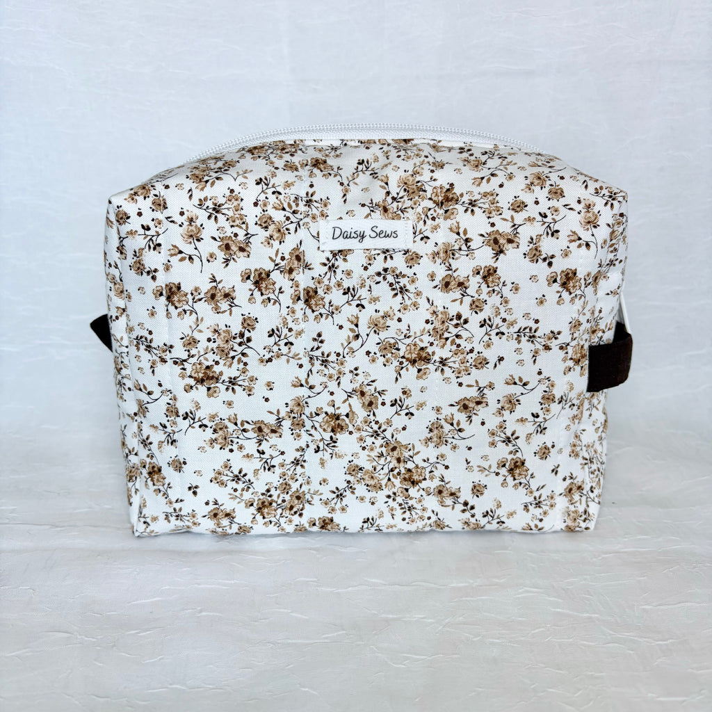 Floral-patterned pouch with 'Daisy Street' branding on a light gray background