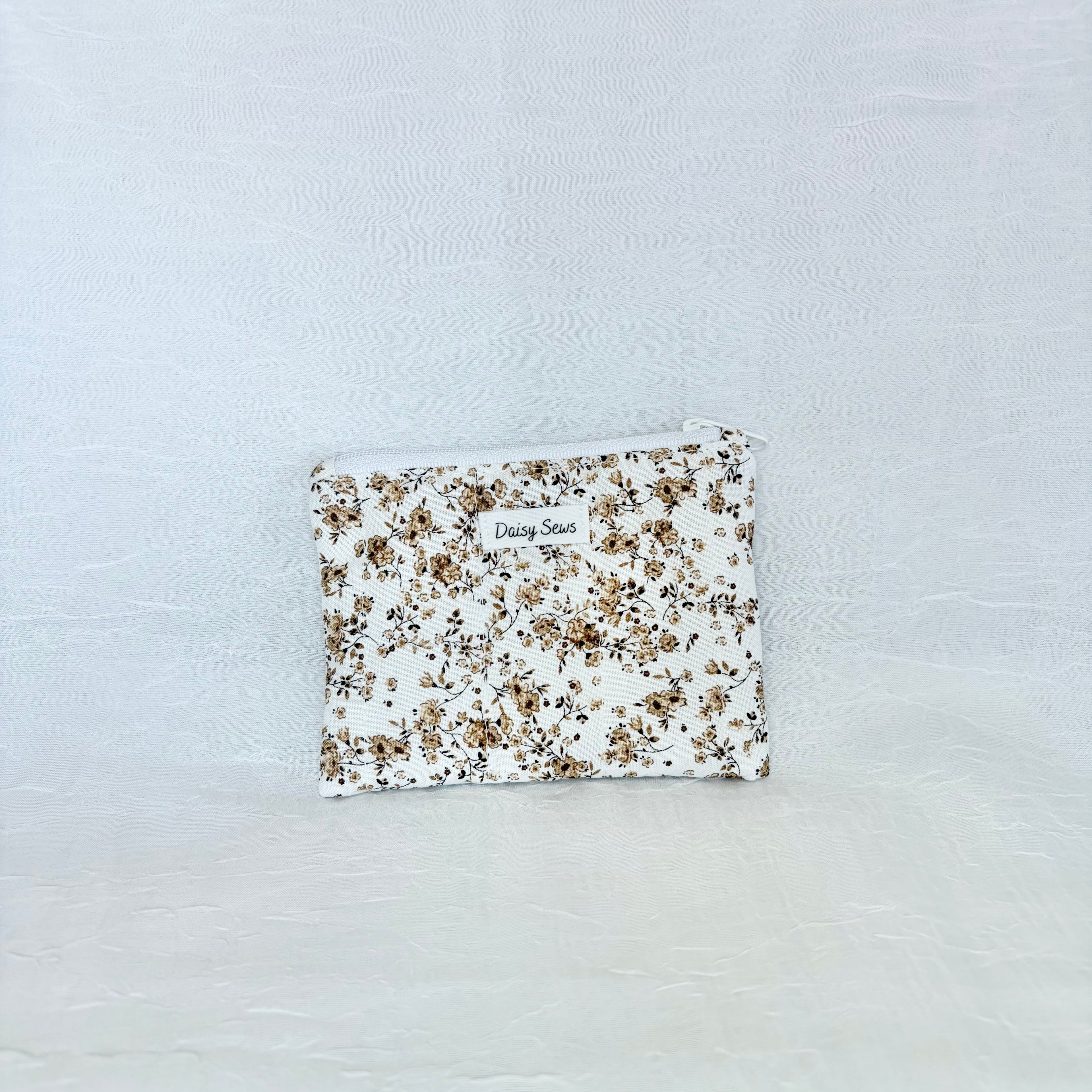 brown Floral patterned pouch on a light gray background