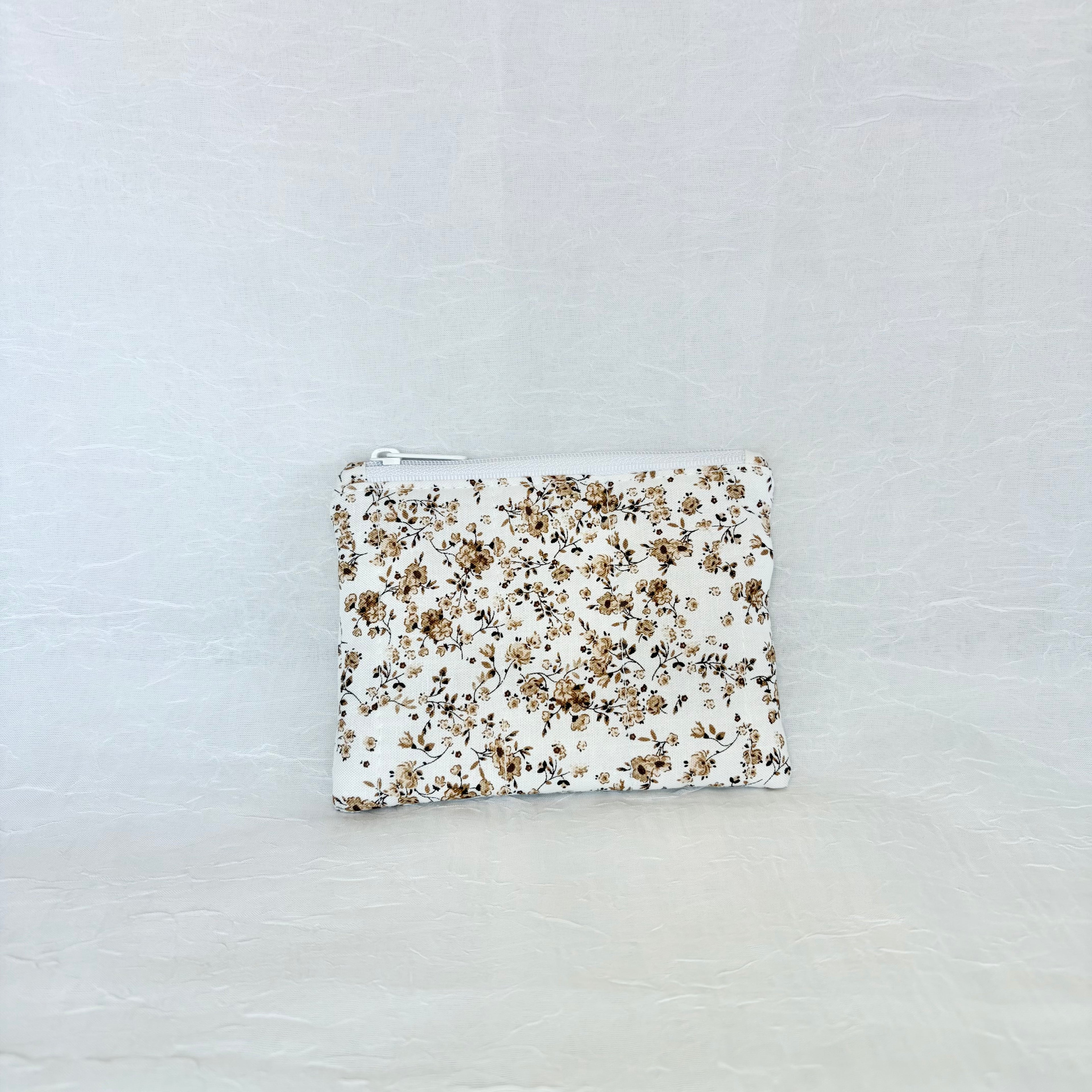 brown Floral-patterned pouch on a light gray background