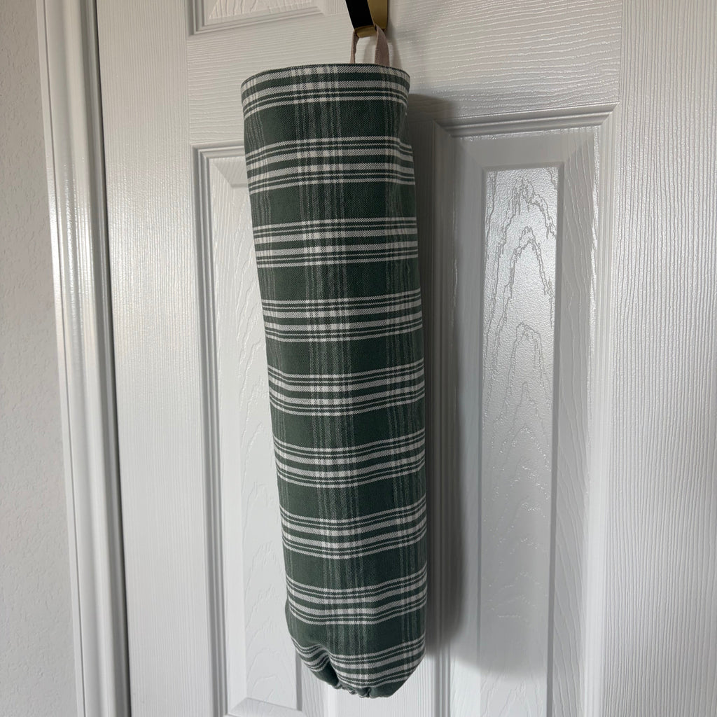 Green and White Plaid fabric in cylindrical shape with tan hook at the top and elastic on the bottom