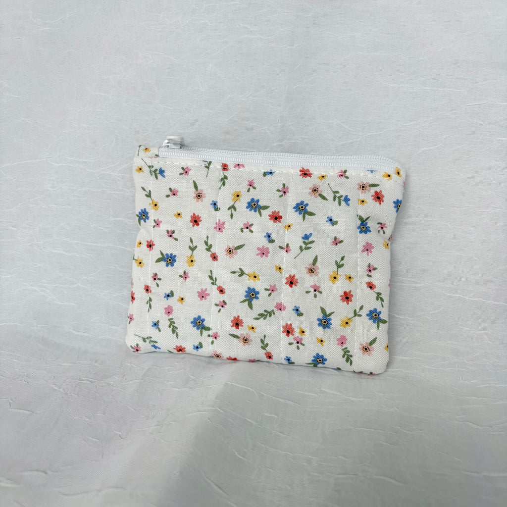 back side Blue, Yellow, Pink, and red flower design on small white pouch with white zipper on white background