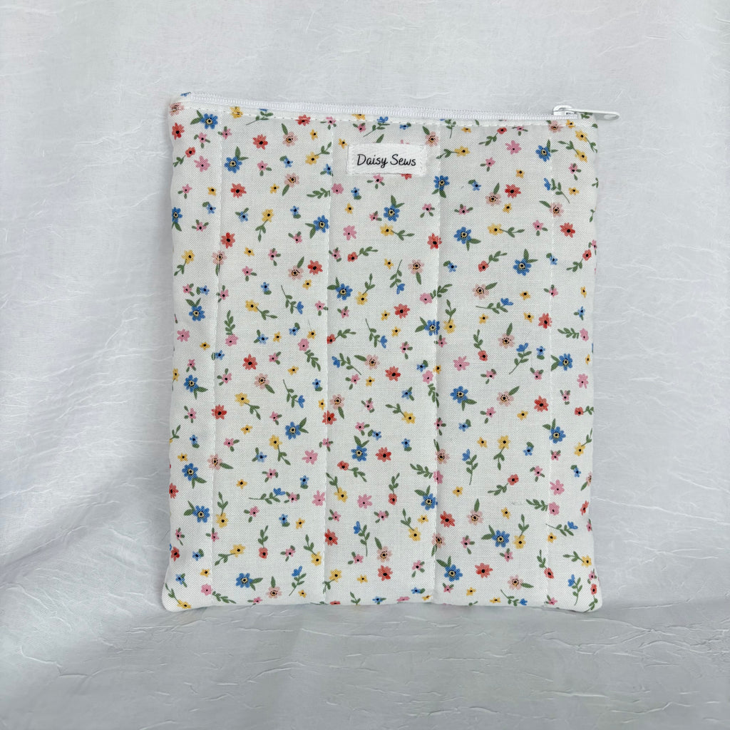 small blue, yellow, pink and red flowers with green leaf design on white fabric, plush flat pouch with white zipper on white background