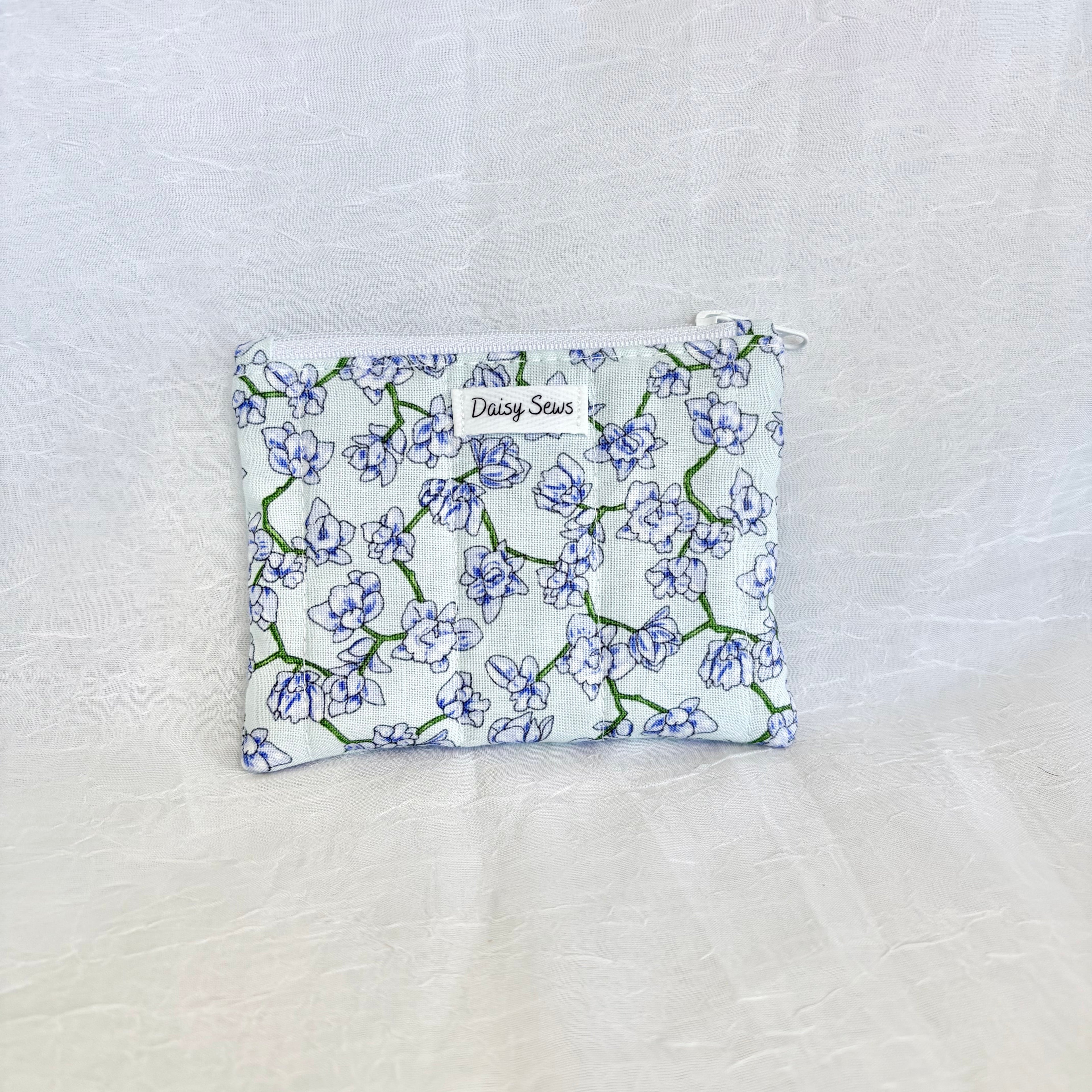 purple blue Floral-patterned pouch on a textured white background