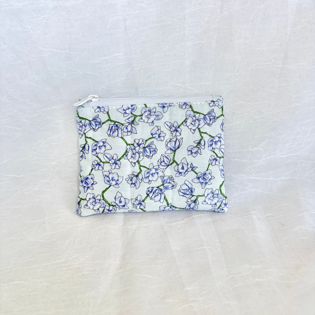 Small pouch with purple blue floral pattern on a white fabric background