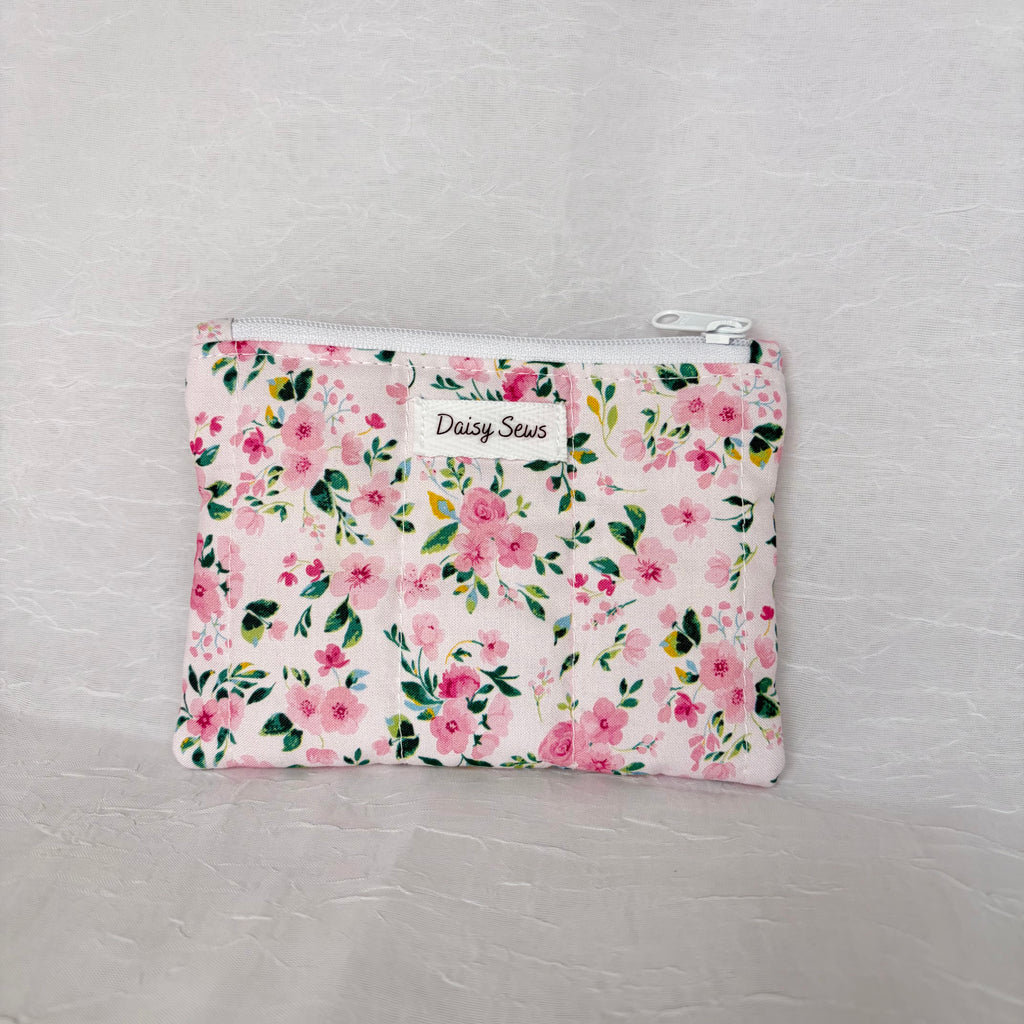 Prink floral with green leaf accent patterned small pouch with white zipper on white background