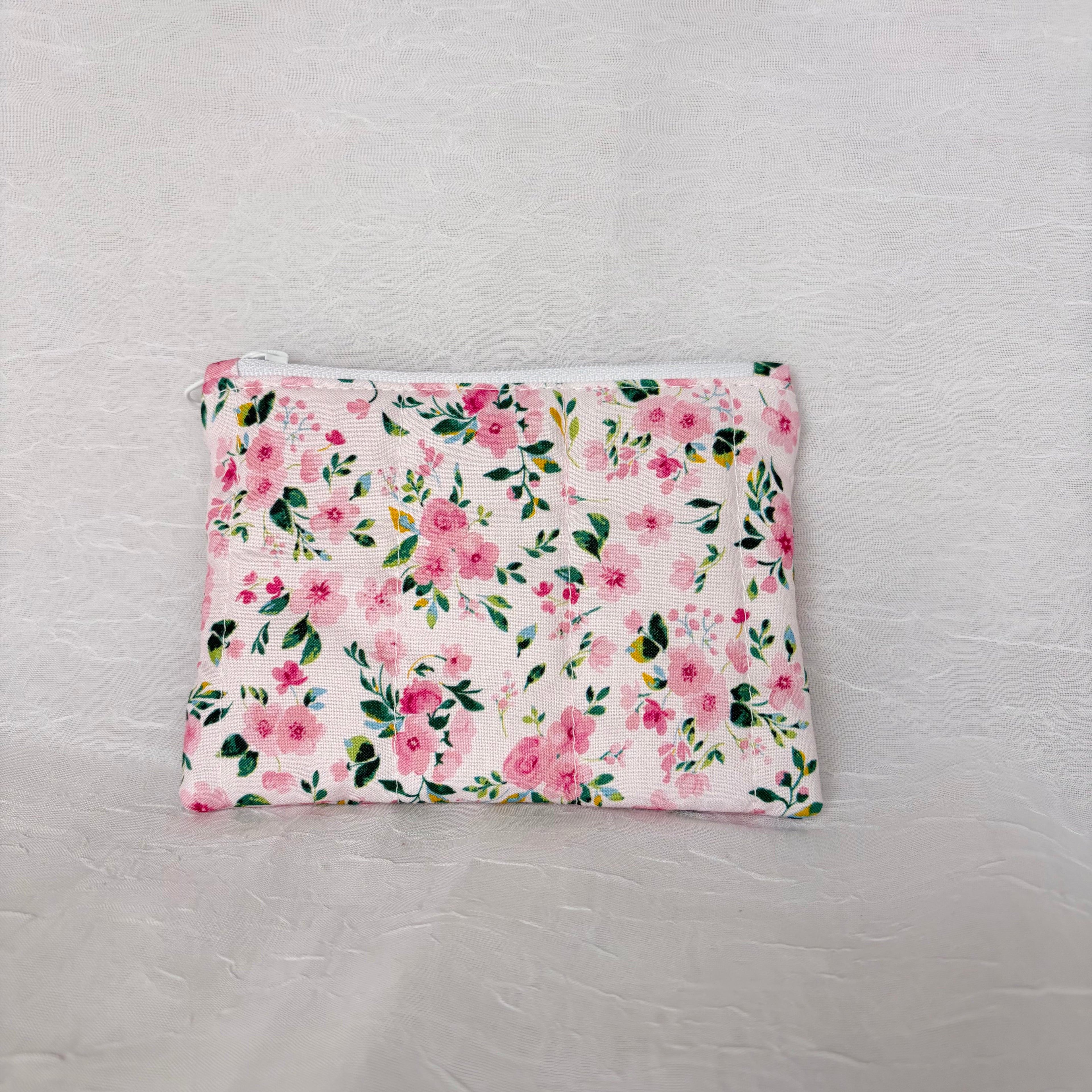 back of Prink floral with green leaf accent patterned small pouch with white zipper on white background