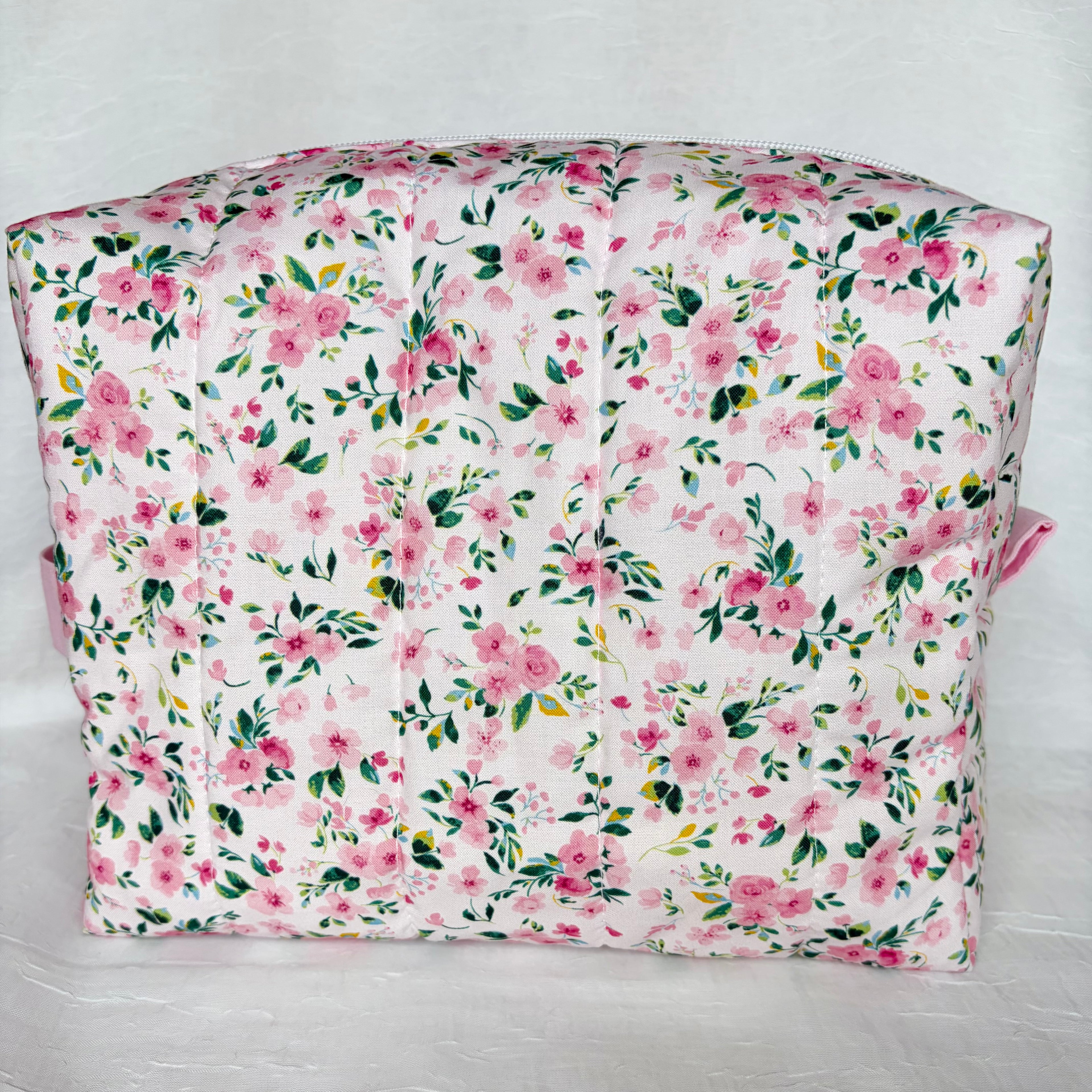 back view of pink and green floral boxy bag on white background