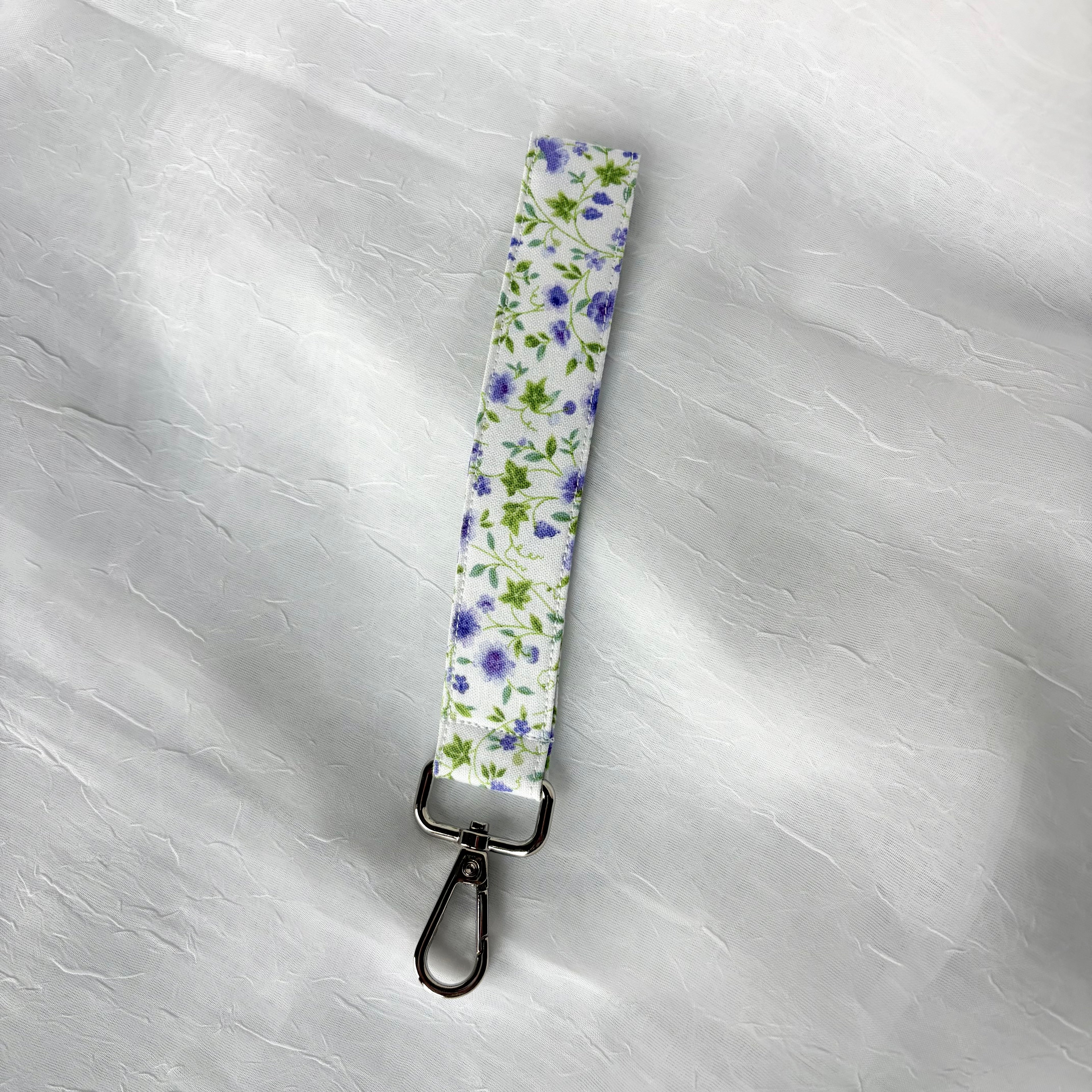 purple flowers with green leaves on white fabric keychain wristlet with silver lobster clip