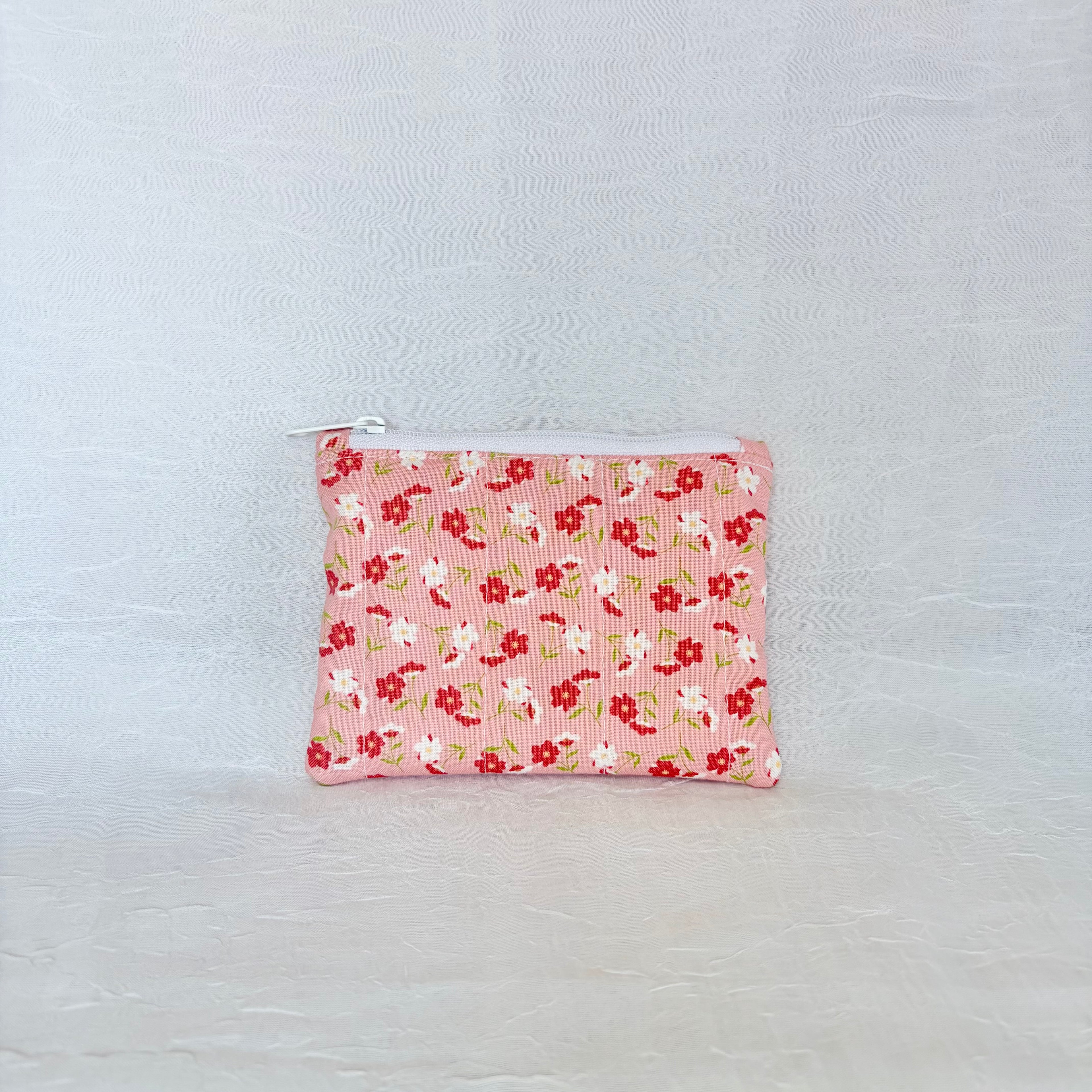 pink Floral patterned pouch on a light gray background