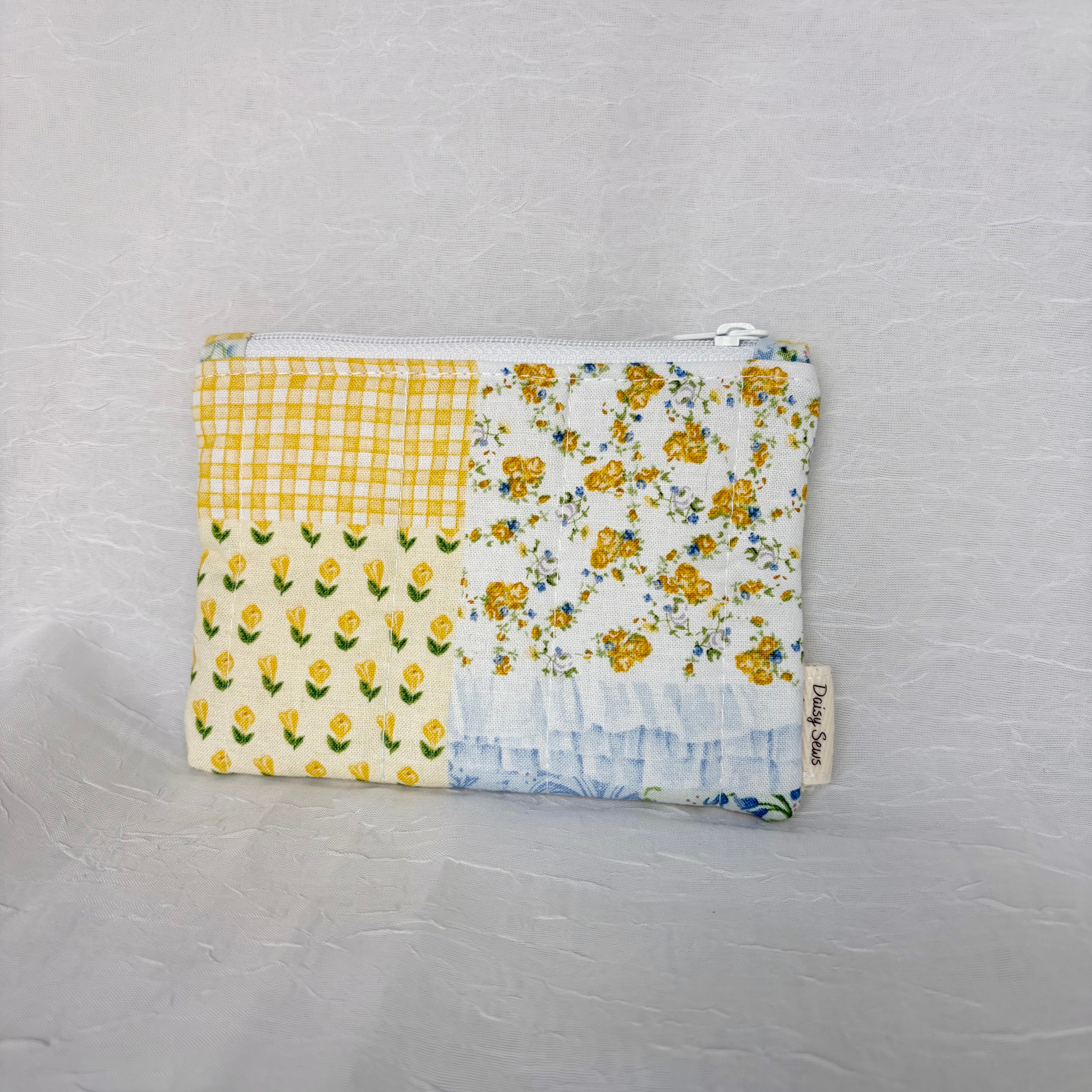 Blue and Yellow floral Patchwork small Pouch with cream tag on bottom right corner on white background